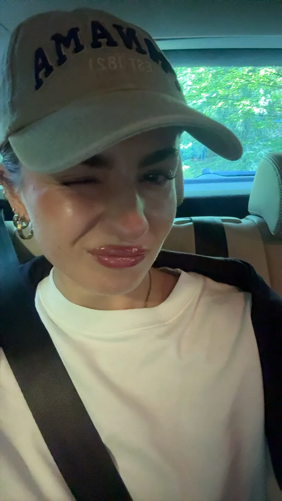 Marie winking at the camera in a baseball cap